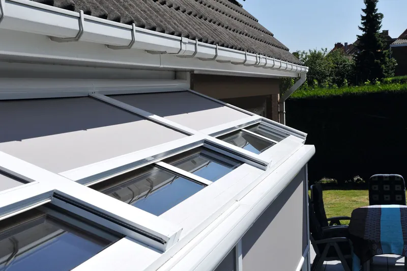Weiße Terrassenüberdachung mit aufliegender Sonnenschutzmarkise
