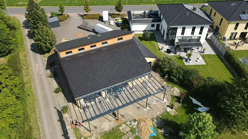 Montage einer großen Terrassenüberdachung an einem Wohnhaus