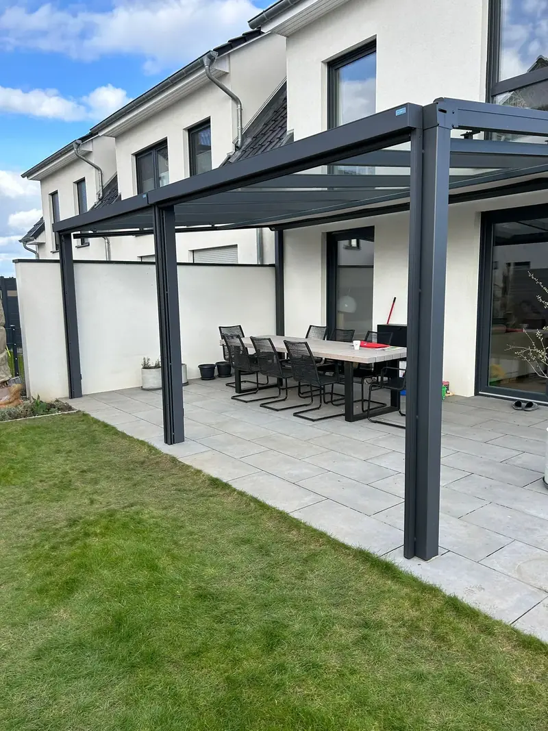 Terrassenüberdachung aus anthrazitfarbenem Aluminium mit klarer Glaseindeckung